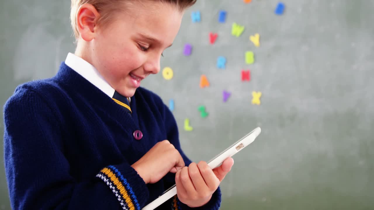 교실 에서 디지털 태블릿 을 사용하는 학교 소년