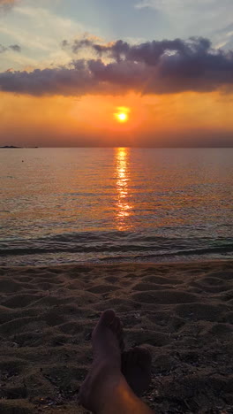 video vertical, puesta de sol sobre el mar mediterráneo horizonte y playa de arena