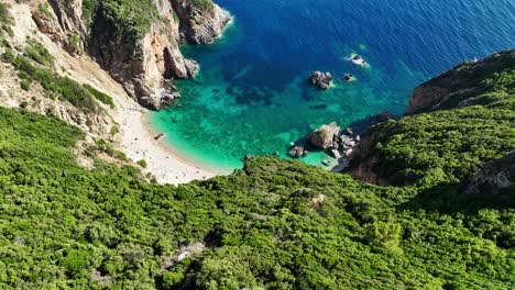 Giali-Strand-Auf-Korfu-Mit-Türkisfarbenem-Wasser,-Umgeben-Von-Grün-Und-Klippen,-Luftaufnahme