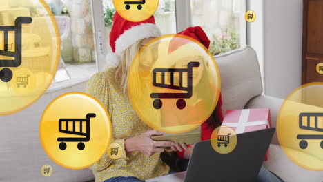 animación de iconos de carretillas de compras en línea sobre madre y hija caucásicas en navidad