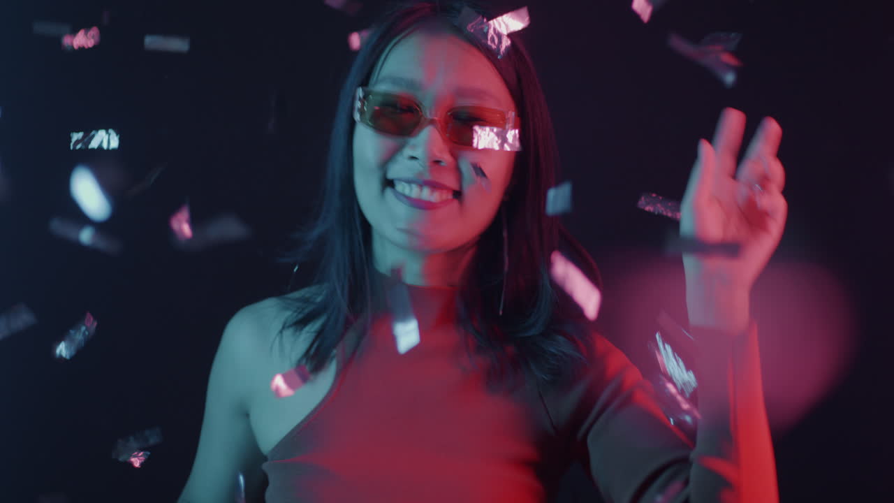 Joyful Woman Dancing with Confetti in Neon Lights