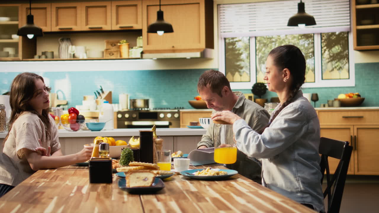 Preoccupied working dad studying work reports and documents at breakfast