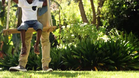 close up of little boy swinging with his father
