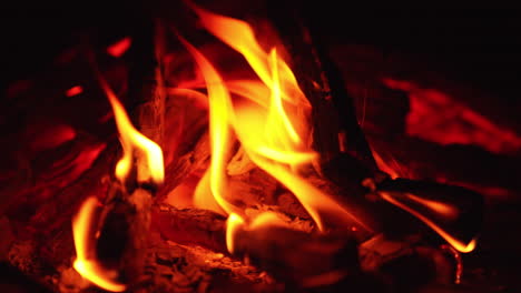 beautiful red hot embers of burning out wood. close up. two sticks are still burning.