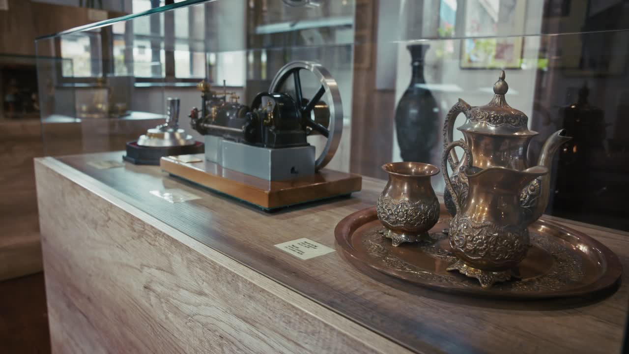 Exhibit of antique metal tea set and machinery in Kumrovec museum, showcasing history