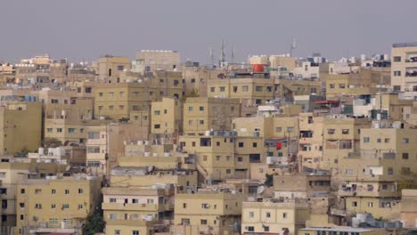 bandada de palomas volando sobre casas densamente abarrotadas y vista del paisaje urbano en la ciudad capital de ammán en jordania