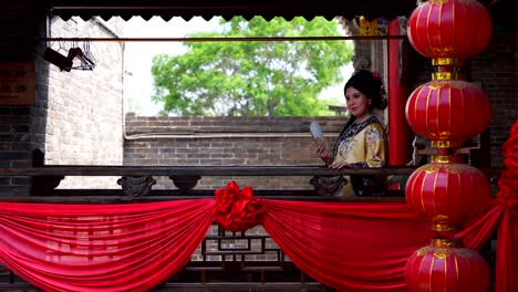 una niña de la dinastía qing con ropa tradicional sonríe en un balcón chino decorado en pingyao, china