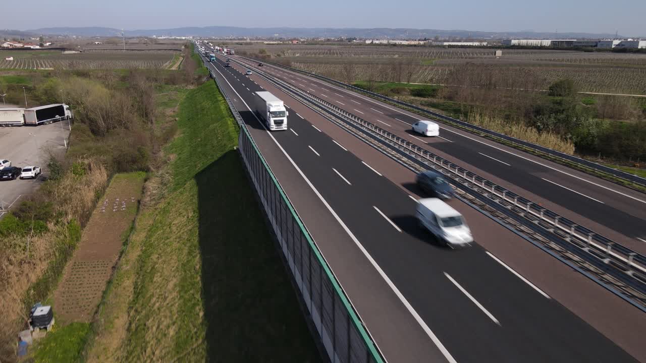 Riprese aeree con drone che mostrano una fluida carrellata in avanti in movimento inverso sopra l'autostrada A4 vicino a Verona, Italia.