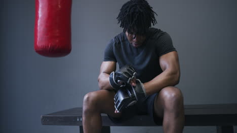 man in boxing gear sitting and relaxing