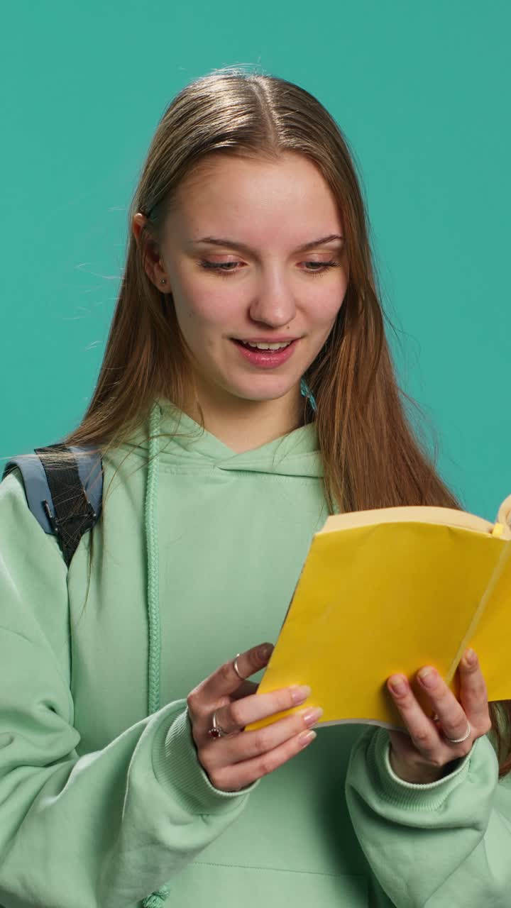 Video verticale Adolescente con libro in mano che mostra apprezzamento per la letteratura