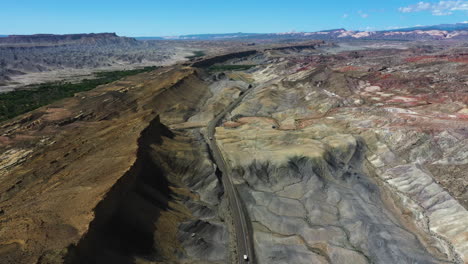 Vista-Aérea-Con-Vistas-A-Un-Vehículo-Que-Circula-Por-Una-Carretera-Desértica-En-Medio-Del-Sur-De-Estados-Unidos