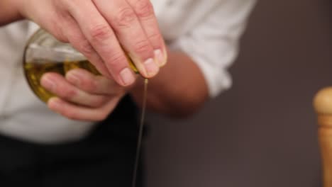 el chef vertiendo aceite de oliva