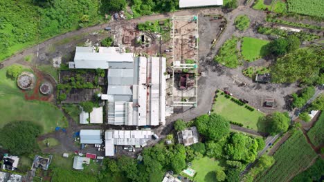 Eine-Zuckerplantage-Mit-Fabrik-Inmitten-üppiger-Vegetation,-Luftaufnahme