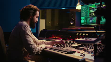 portrait of sound engineer recording audio and editing with mixing console