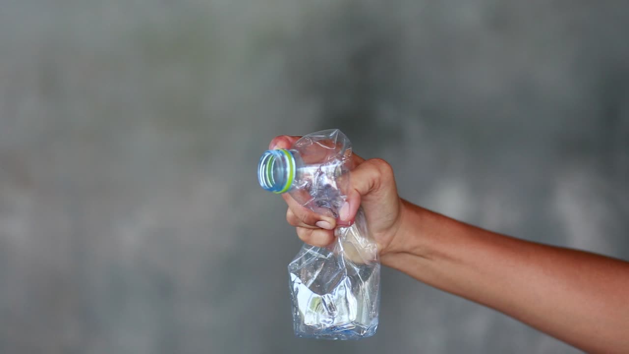 aplastar con la mano una botella de plástico