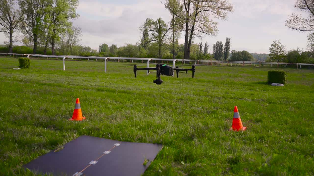 Filmmaking drone perform landing procedure on specialized surface near cones