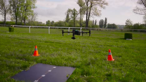 filmmaking drone perform landing procedure on specialized surface near cones