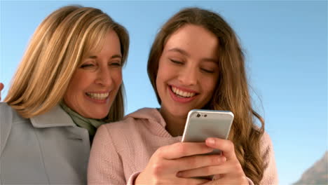 madre e hija usando un teléfono inteligente