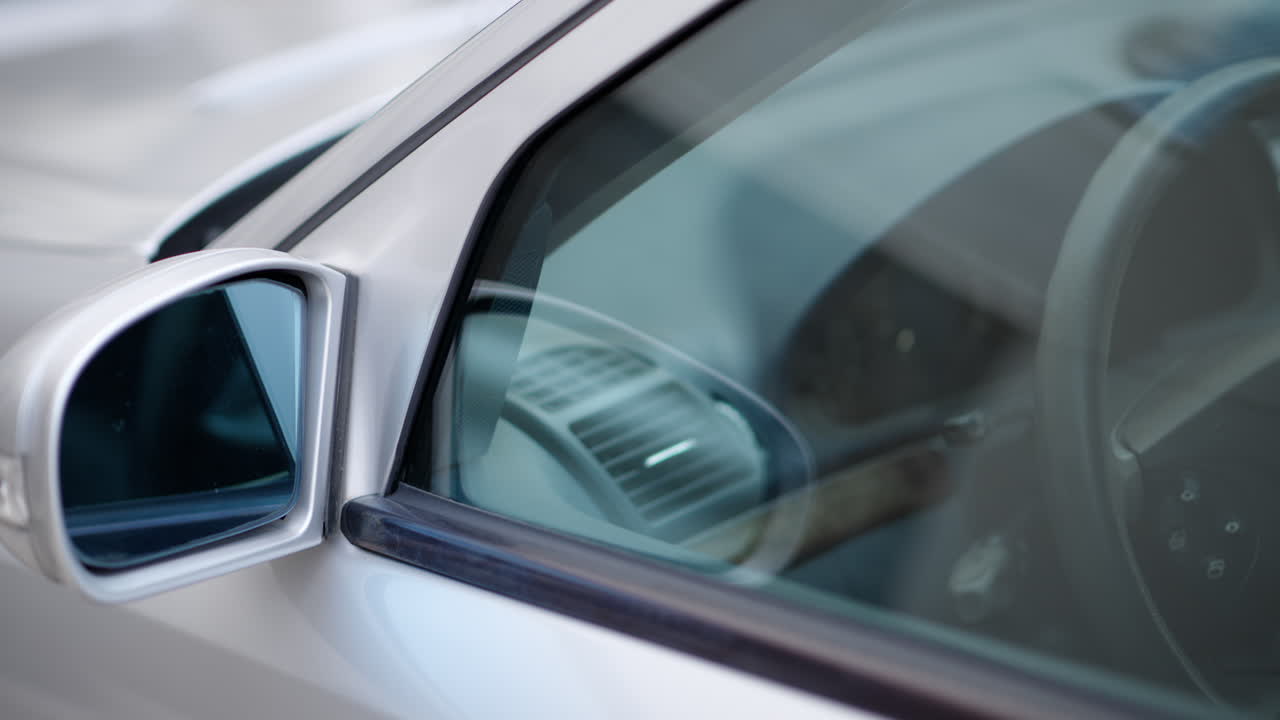 Close up of the mirror and the front window of a silver car