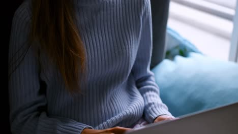 Woman using laptop at home 4k