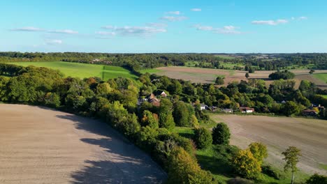 escena de la campiña británica con cielos azules y exuberantes árboles y campos verdes