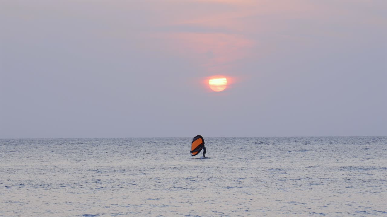 Kite wind surfing water sport sailing wind power at sunset Caribbean Sea Colombia shore