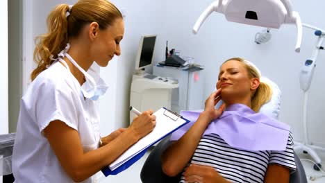 Dentist-interacting-with-female-patient