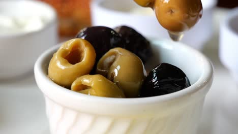 closeup of green olives and black olives in a bowl