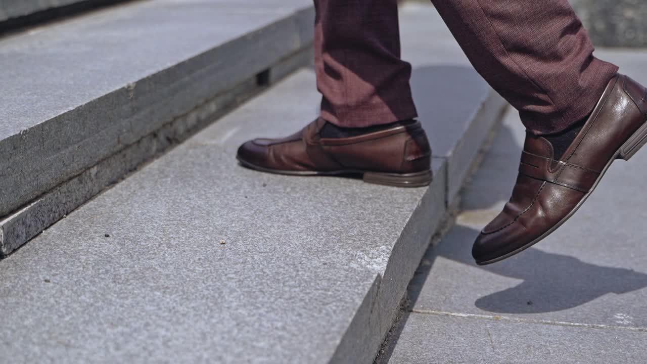 Businessman walking upstairs outside. Close up legs of businessman walking stepping up stair