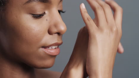 retrato de cerca de una hermosa mujer afroamericana tocando suavemente el rostro con las manos disfrutando de una piel suave y saludable, una piel sana, belleza femenina natural, concepto de cuidado de la piel