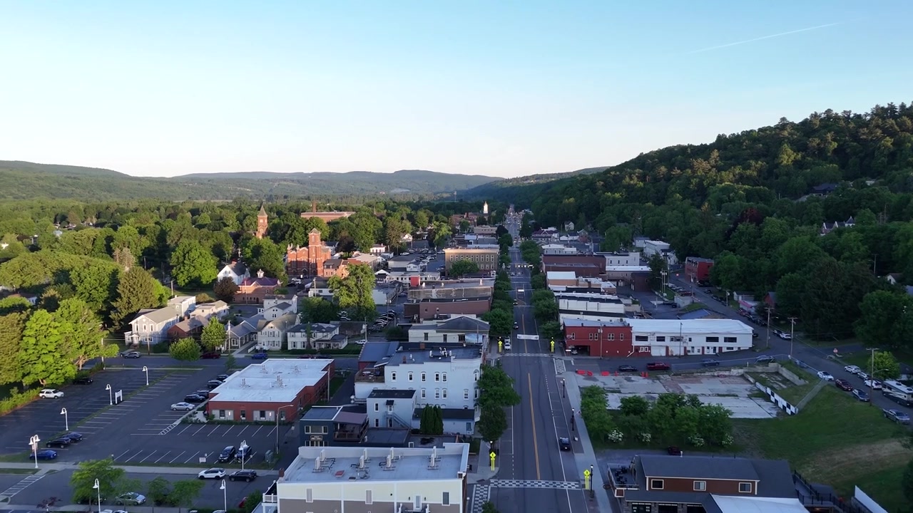 Luftdroneudsigt, der sporer over hovedgaden i Watkins Glen by, New York. Filmisk højvinkel-layout af det kommercielle centrum i Upstate, flankeret af sommerbakker.