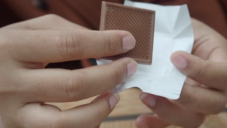 person unwrapping a chocolate bar