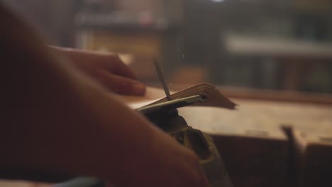 a carpenter saws a skateboard out of a wooden board using a jigsaw