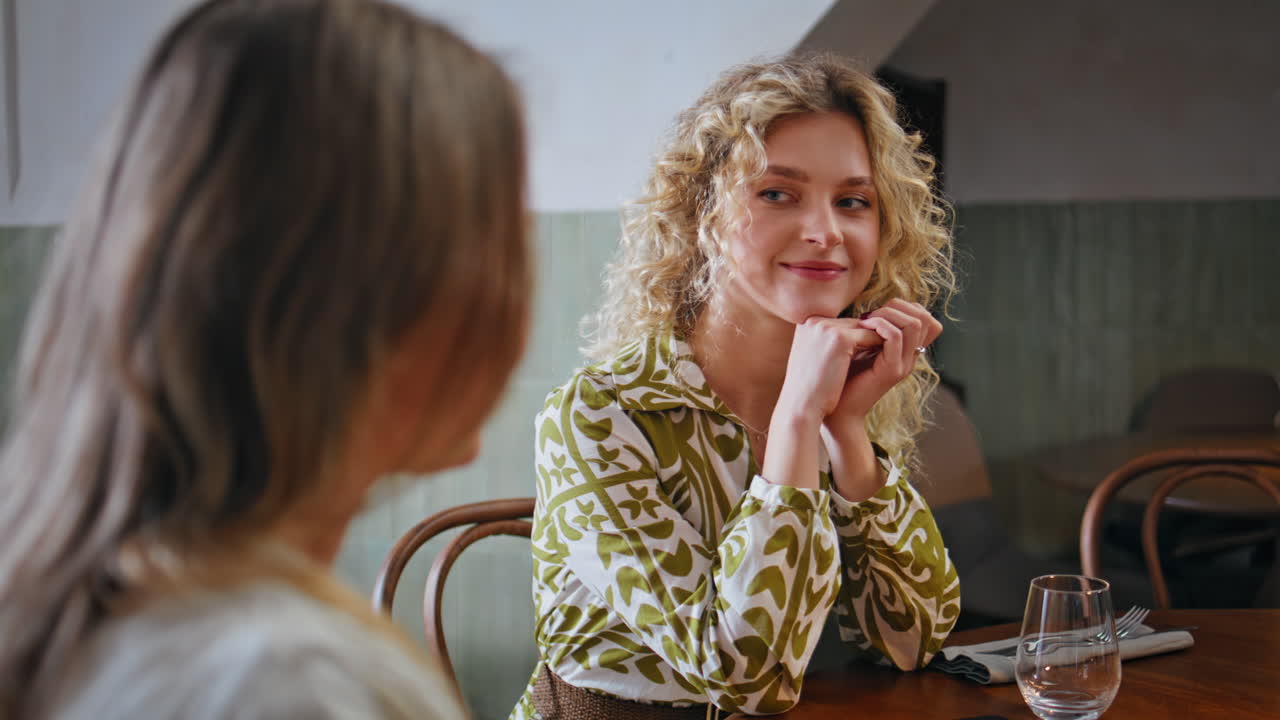 Close-up de uma mulher loira conversando com uma amiga em um café aconchegante. Senhora calma sorrindo