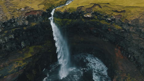 mulafossur waterfall, faroe islands: fantastic aerial view in orbit over the beautiful waterfall and the wind hitting the water