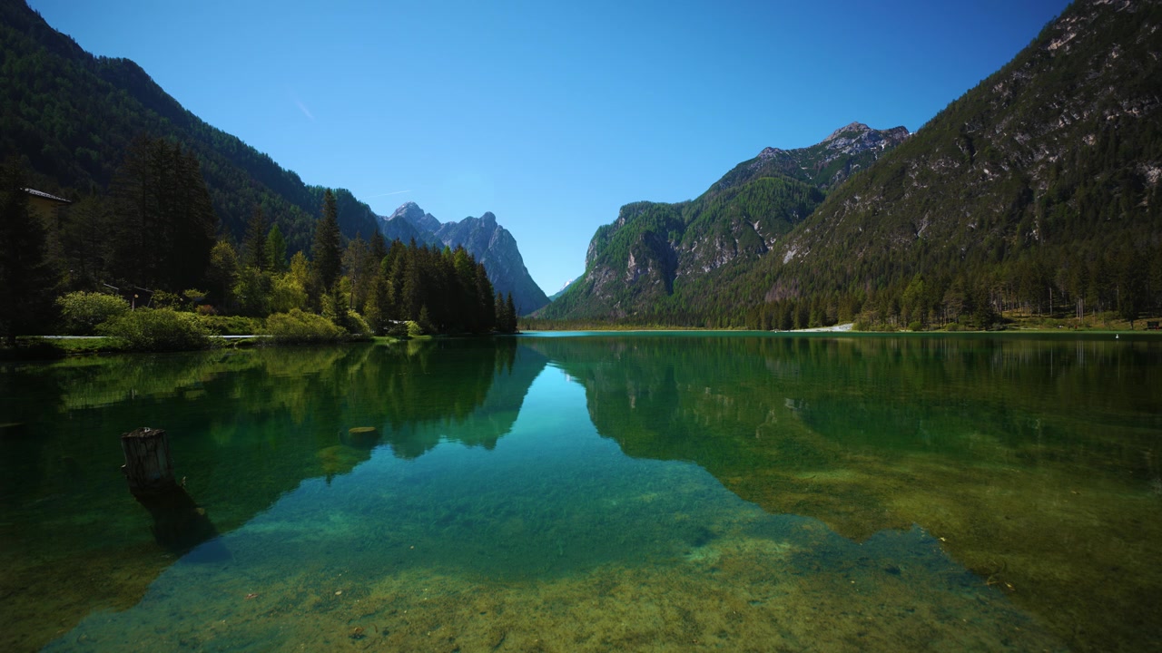 Lago di Dobbiaco, popolare destinazione turistica con acqua limpida e pedalò a noleggio in Alto Adige, Italia.