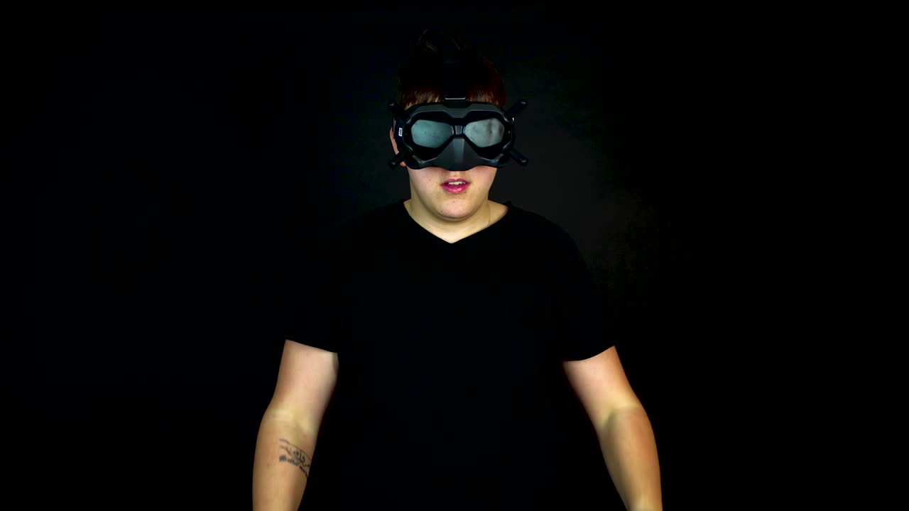 Giovane uomo che indossa un visore VR in prima persona, scatto in studio su sfondo nero