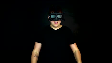 young man wearing vr first person view headset, studio shot on black background