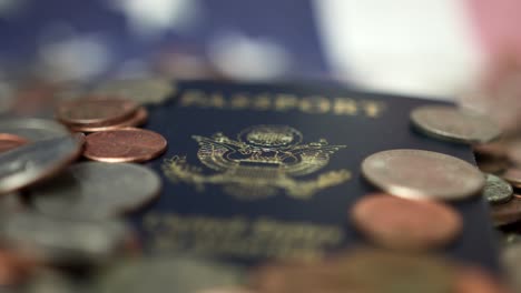 montón de monedas de dólar y pasaporte de ee.uu. sobre la bandera americana