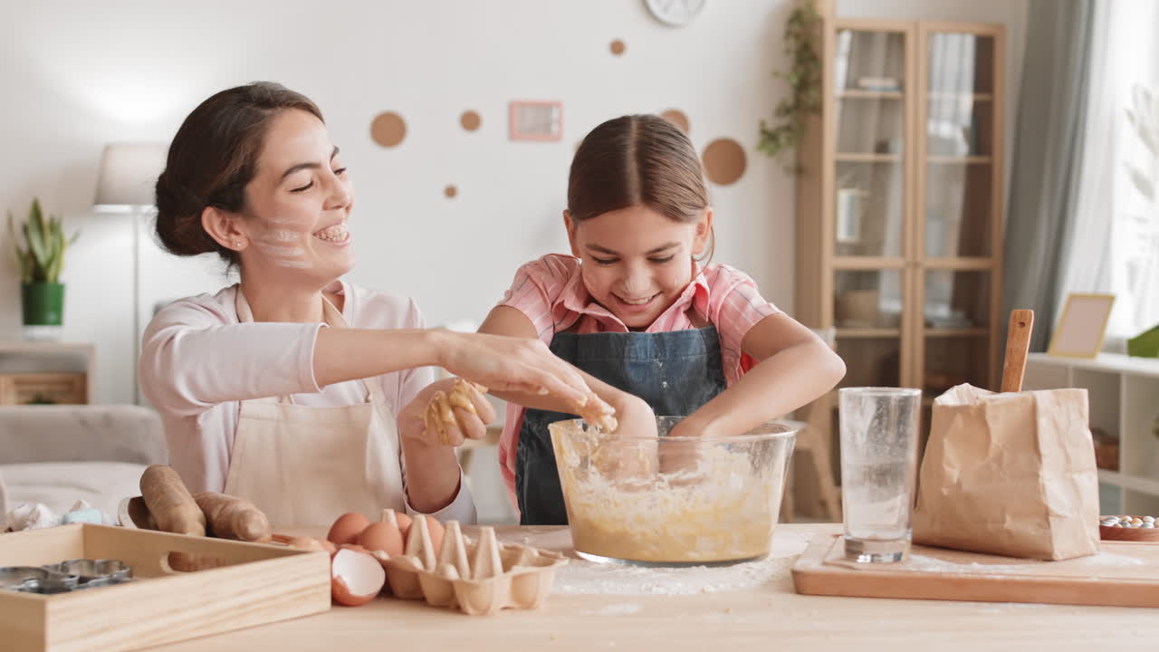 Caucasian Girl and Her Attractive Mother Kneading Dough