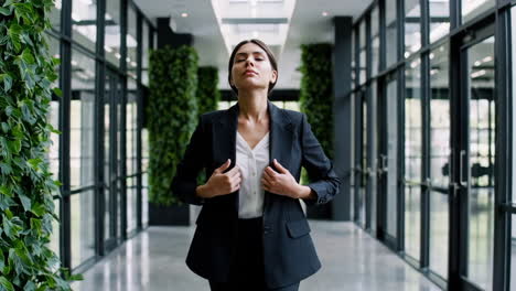 confident businesswoman in a modern office hallway with green walls