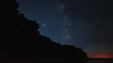 cinemagraph time-lapse ciclo de video sin problemas del cielo nocturno europeo y la vía láctea con miles de estrellas en el universo y el sistema solar astronómico. visto desde una playa en croacia con algunos barcos que pasan en verano.