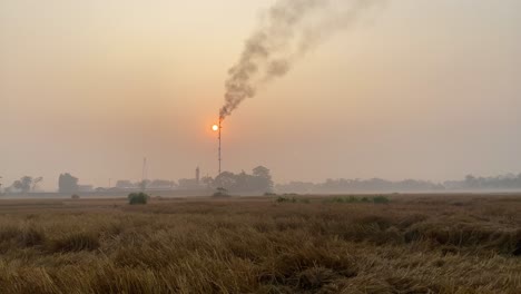 establisher pan revealing gas plant burning flame releasing polluting fumes