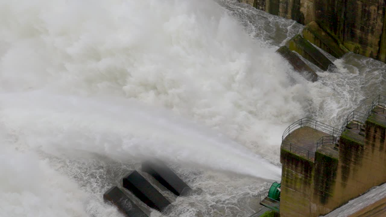 Sau pantano overflowing, january 2026 massive volumes of turbulent water gushing at high pressure from a concrete dam's release gates, a powerful force of nature
