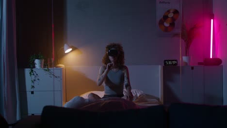 woman experiencing vr in her bedroom at night