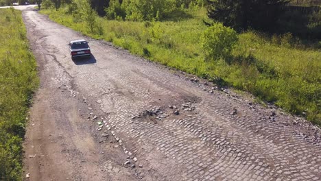 damaged cobblestone road with car