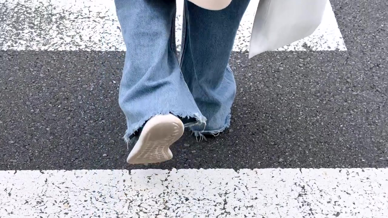 Persona che attraversa un passaggio pedonale in ambiente urbano