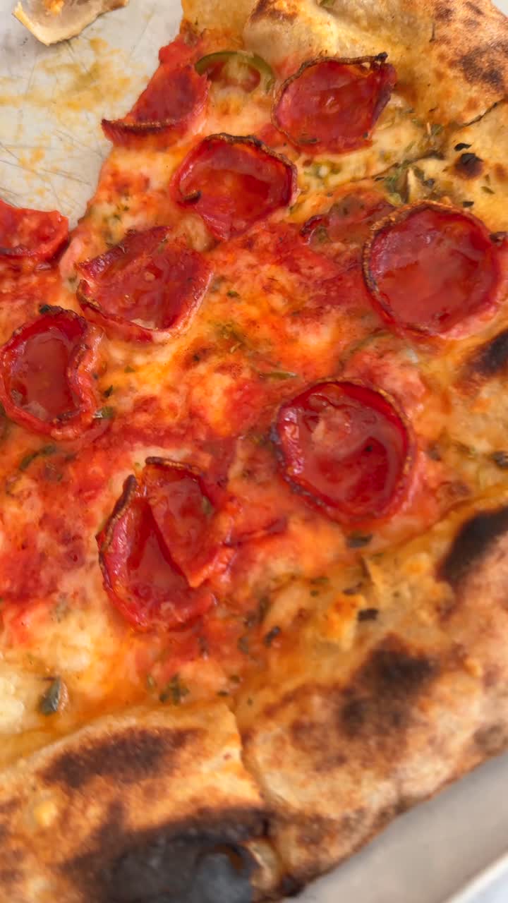 Persona che mangia pizza ai peperoni