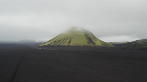 Luftaufnahme-Des-Grünen-Maelifell-Vulkans-Auf-Island,-Umgeben-Von-Dichten-Wolken-Und-Nebel