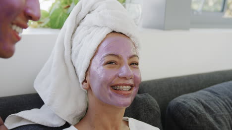 Young-biracial-woman-enjoys-a-facial-mask-at-home